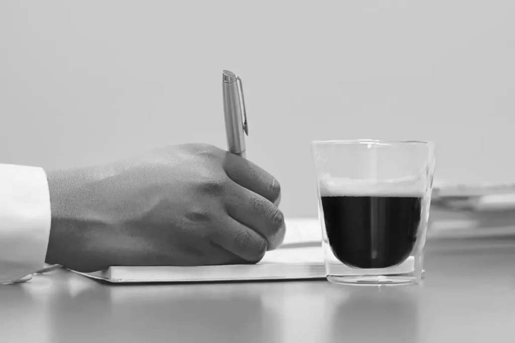 Hand mit Stift auf Papier – Bewerbung ohne Anschreiben per WhatsApp